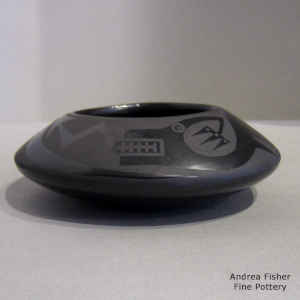 An avanyu and feather design on a black on black bowl