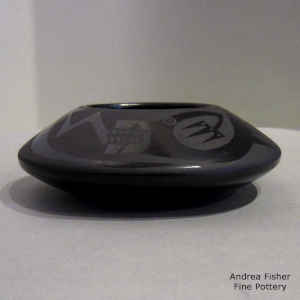 An avanyu, cloud and geometric design on a black on black jar