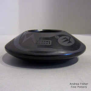 An avanyu and feather design on a black on black jar