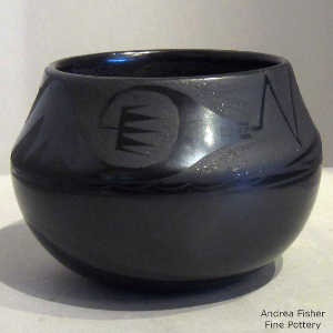 An avanyu design on a black on black jar