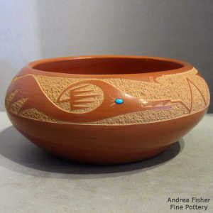 Micaceous slip inside and sgraffito avanyu design outside on a red bowl