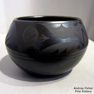 An avanyu and geometric design on a black on black bowl