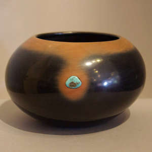 Two pieces of inlaid turquoise on a black jar with sienna rim