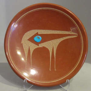 Sgraffito animal design and inlaid turquoise on a polished red plate
