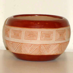 Sgraffito geometric design on a polished red and matte tan bowl