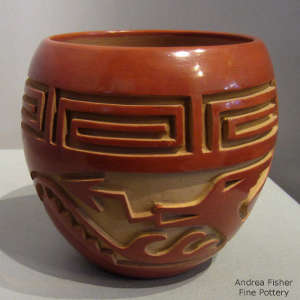 Avanyu and geometric design carved into a polished red jar