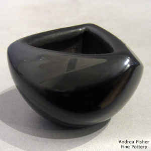 Geometric design on a miniature black on black jar with a triangular opening