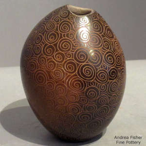 Sgraffito spiral geometric design on a polished dark brown jar