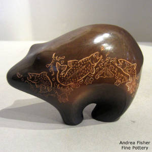 Sgraffito fish designs on a polished brown bear