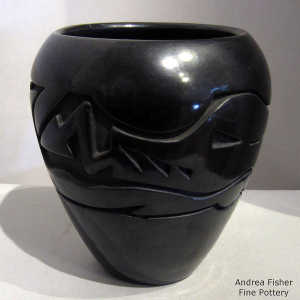 An avanyu design carved into a black jar