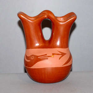 An avanyu and geometric design on a red wedding vase