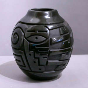Kachina and geometric design carved into a black jar