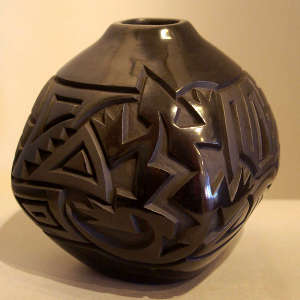 Lizard and geometric design carved into a squarish black on black jar