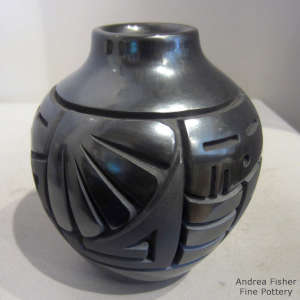 A geometric design carved into a black on black jar