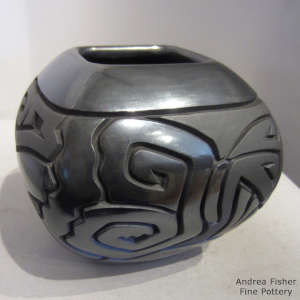 Geometric design carved into a squarblack on black jar