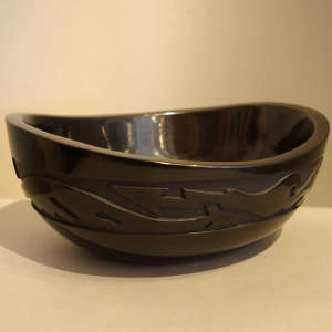 Avanyu design carved into the outside of an oval black bowl polished inside and out