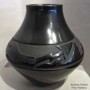 An avanyu design carved into a black jar