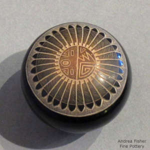 Sgraffito feather and geometric design on a black seed pot with sienna spot