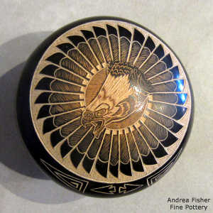 Sgraffito arrowhead, eagle head, feather and geometric design on a black seed pot with a sienna spot