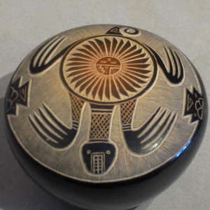 Sgraffito turtle, feather, cloud and geometric designs on a black seedpot with sienna spots