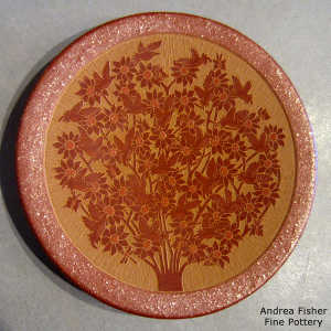 Micaceous rim and back on a red plate with a sgraffito hummingbird and flowering bush design