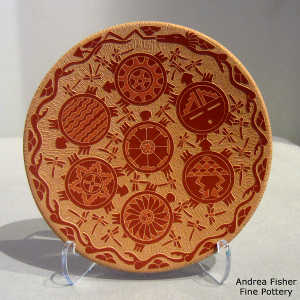Sgraffito avanyu, turtle, dragonfly and geometric design on a red plate