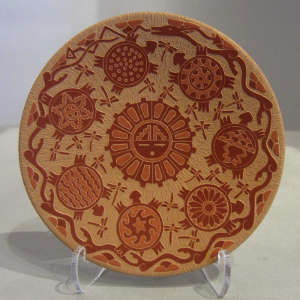Sgraffito turtle, dragonfly and geometric design on a red plate