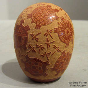 Sgraffito hummingbird, turtle, flower, avanyu and geometric design on a red seed pot