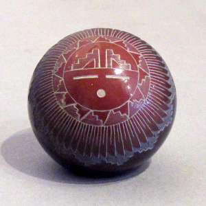 Sgraffito sun face, feather and geometric design on a black seed pot with a sienna top