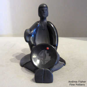 Inlaid stone on a plate on a black storyteller with two children