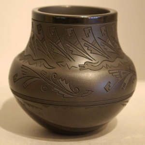 Avanyu and geometric design carved into a black on black jar