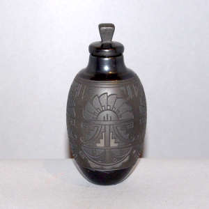 Lightly carved medallion, kiva step and geometric design on a micaceous black on black lidded jar