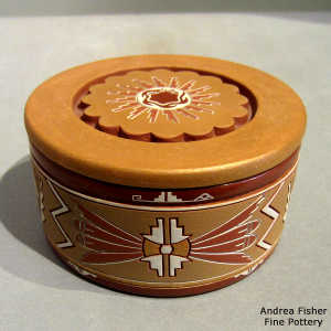 Lightly carved, sgraffito and painted geometric design on a lidded polychrome jar