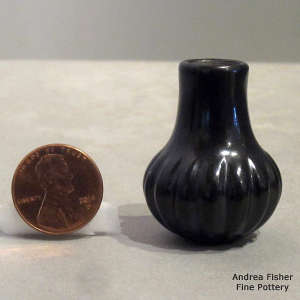 Tall neck miniature black jar carved with a melon design