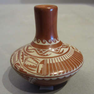 Feather and geometric designs on a red miniature jar