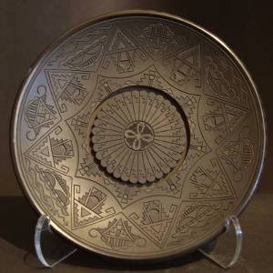 Click to see a larger version Feather and geometric designs carved into a black plate