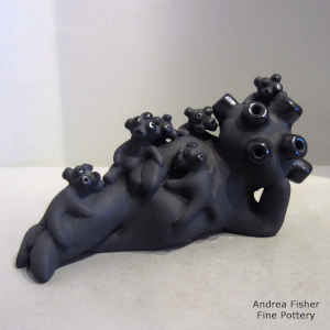 6 mudhead children on a lounging black mudhead storyteller