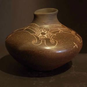 Sgraffito turtles, dragonflies and geometric designs on a low shouldered brown jar with an organic opening