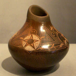 Sgraffito turtle, dragonfly and geometric design on a brown jar with an organic opening
