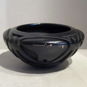 Carved bear and geometric designs plus sgraffito designs on a black bowl