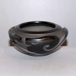 An avanyu design carved into a black bowl