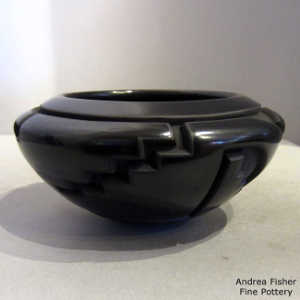 An avanyu, kiva step and geometric design carved into a black bowl