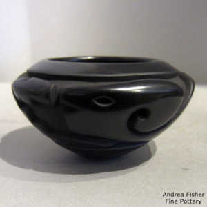 An avanyu design carved into a black bowl