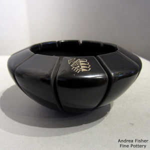 Melon design carved into a black bowl with a sgraffito geometric design