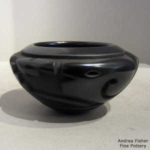 Carved bear and geometric designs plus sgraffito designs on a black bowl