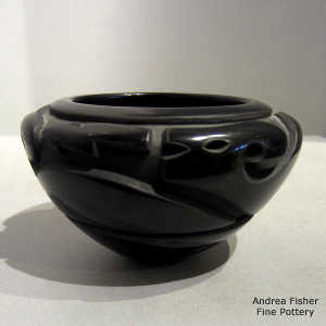 An avanyu design carved into a black bowl