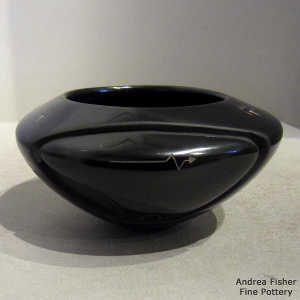 Bear design carved into a black bowl with sgraffito bear paws and heart line