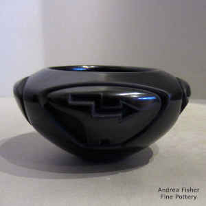 A bear with heart line design carved into a black bowl