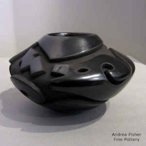 An avanyu design carved into a black bowl