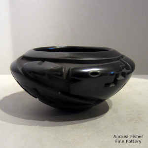 An avanyu design carved into a black bowl